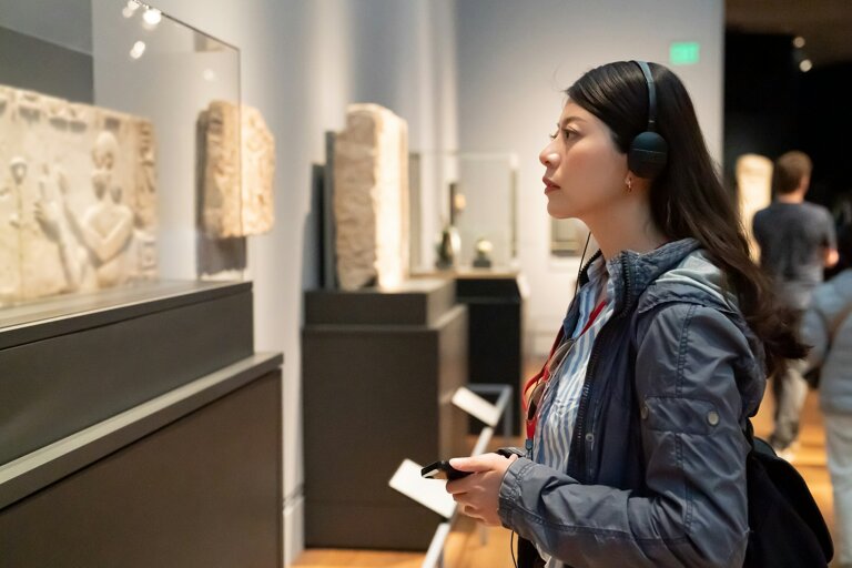 girl taking audio tour in the history museum
